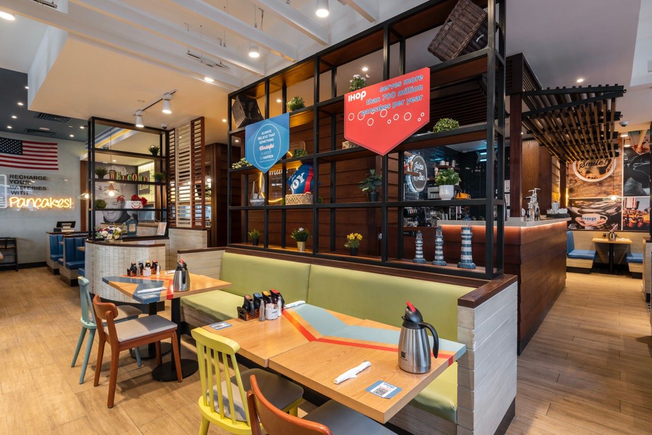 A wide-angle, exterior view of the **Lloyd's Building** in London, showcasing its distinctive inside-out architecture with exposed pipes, ducts, and service elements on the facade. The building stands tall against the skyline, reflecting the surrounding urban environment.