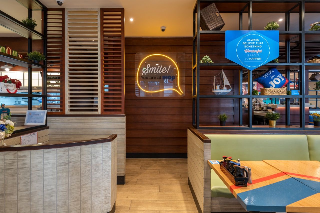 A wide-angle, exterior view of the **Lloyd's Building** in London, showcasing its distinctive inside-out architecture with exposed pipes, ducts, and service elements on the facade. The building stands tall against the skyline, reflecting the surrounding urban environment.