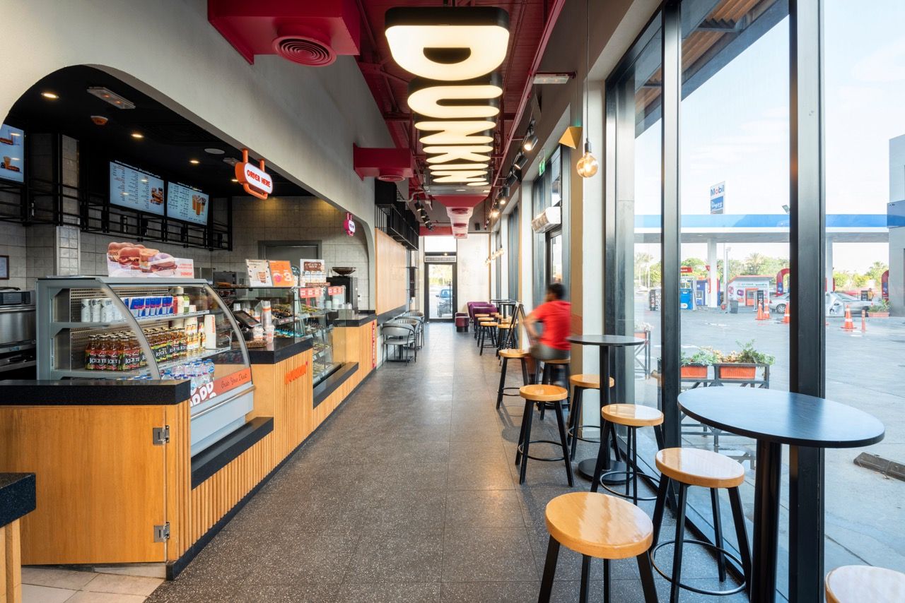 A wide-angle, exterior view of the **Lloyd's Building** in London, showcasing its distinctive inside-out architecture with exposed pipes, ducts, and service elements on the facade. The building stands tall against the skyline, reflecting the surrounding urban environment.