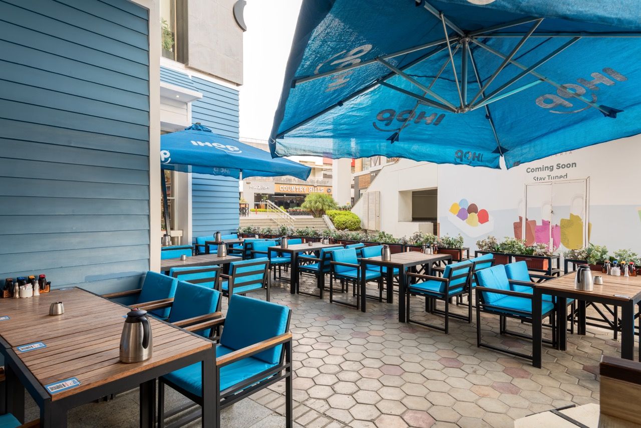 A wide-angle, exterior view of the **Lloyd's Building** in London, showcasing its distinctive inside-out architecture with exposed pipes, ducts, and service elements on the facade. The building stands tall against the skyline, reflecting the surrounding urban environment.