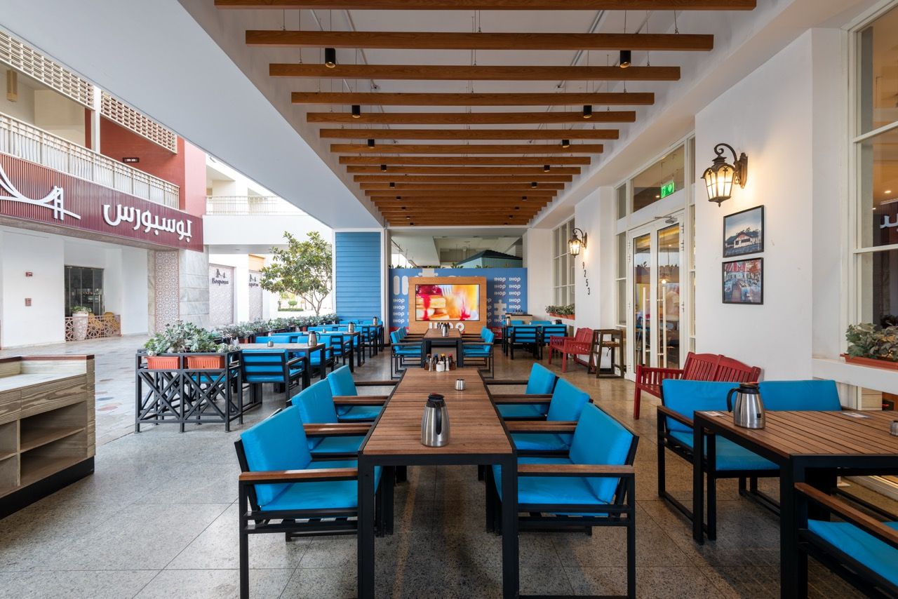 A wide-angle, exterior view of the **Lloyd's Building** in London, showcasing its distinctive inside-out architecture with exposed pipes, ducts, and service elements on the facade. The building stands tall against the skyline, reflecting the surrounding urban environment.