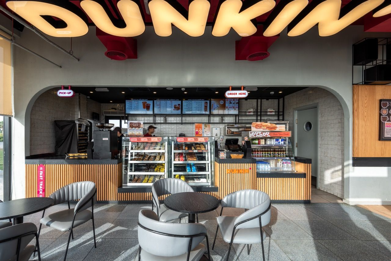 A wide-angle, exterior view of the **Lloyd's Building** in London, showcasing its distinctive inside-out architecture with exposed pipes, ducts, and service elements on the facade. The building stands tall against the skyline, reflecting the surrounding urban environment.