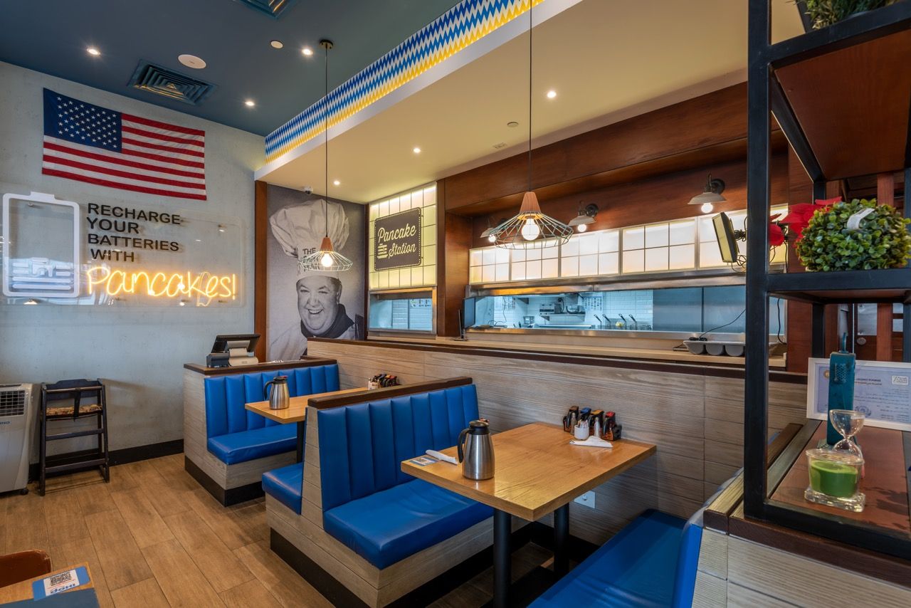 A wide-angle, exterior view of the **Lloyd's Building** in London, showcasing its distinctive inside-out architecture with exposed pipes, ducts, and service elements on the facade. The building stands tall against the skyline, reflecting the surrounding urban environment.