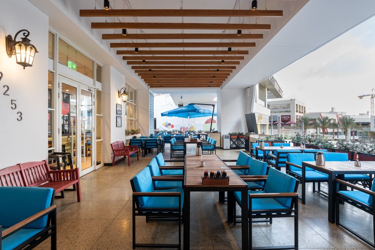 A wide-angle, exterior view of the **Lloyd's Building** in London, showcasing its distinctive inside-out architecture with exposed pipes, ducts, and service elements on the facade. The building stands tall against the skyline, reflecting the surrounding urban environment.