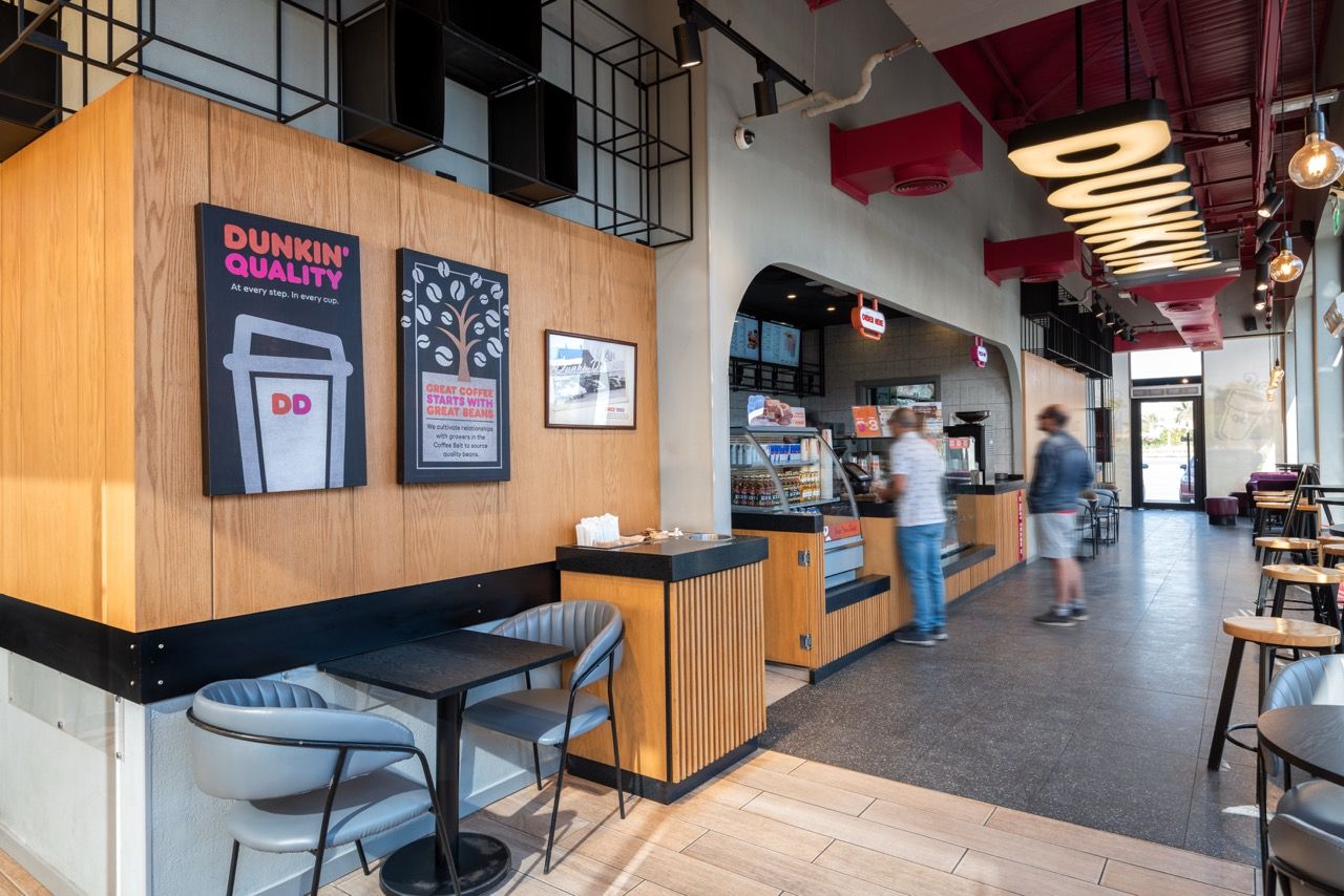 A wide-angle, exterior view of the **Lloyd's Building** in London, showcasing its distinctive inside-out architecture with exposed pipes, ducts, and service elements on the facade. The building stands tall against the skyline, reflecting the surrounding urban environment.