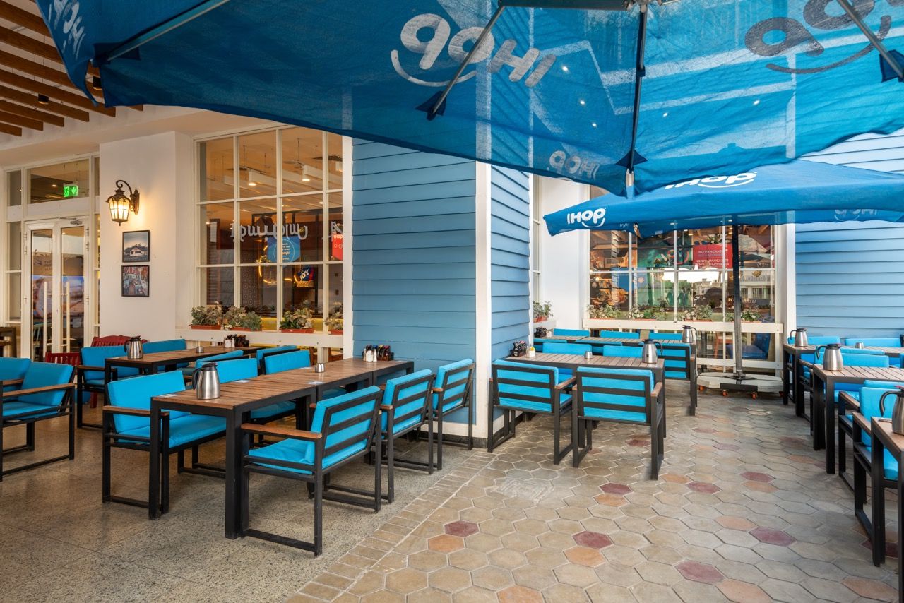 A wide-angle, exterior view of the **Lloyd's Building** in London, showcasing its distinctive inside-out architecture with exposed pipes, ducts, and service elements on the facade. The building stands tall against the skyline, reflecting the surrounding urban environment.