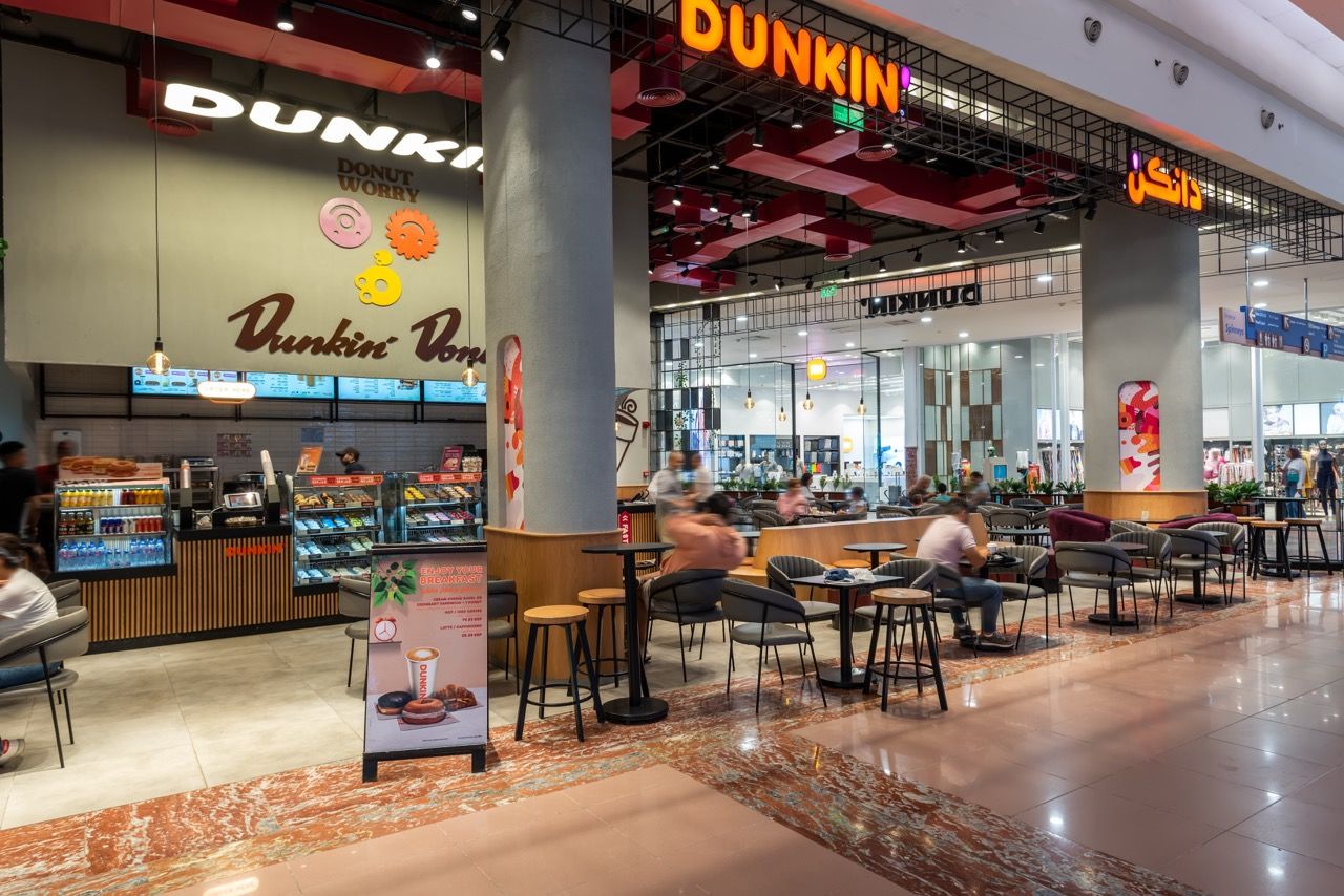 A wide-angle, exterior view of the **Lloyd's Building** in London, showcasing its distinctive inside-out architecture with exposed pipes, ducts, and service elements on the facade. The building stands tall against the skyline, reflecting the surrounding urban environment.