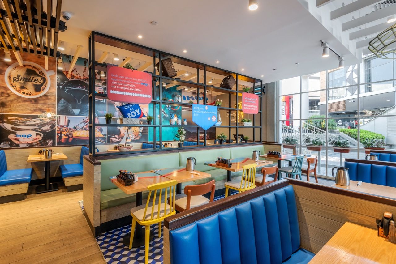 A wide-angle, exterior view of the **Lloyd's Building** in London, showcasing its distinctive inside-out architecture with exposed pipes, ducts, and service elements on the facade. The building stands tall against the skyline, reflecting the surrounding urban environment.