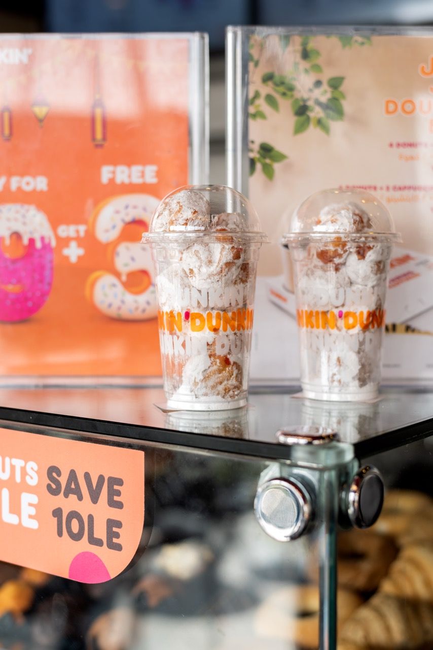 A wide-angle, exterior view of the **Lloyd's Building** in London, showcasing its distinctive inside-out architecture with exposed pipes, ducts, and service elements on the facade. The building stands tall against the skyline, reflecting the surrounding urban environment.