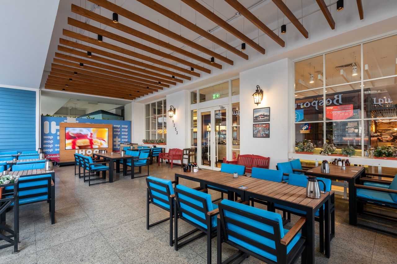 A wide-angle, exterior view of the **Lloyd's Building** in London, showcasing its distinctive inside-out architecture with exposed pipes, ducts, and service elements on the facade. The building stands tall against the skyline, reflecting the surrounding urban environment.