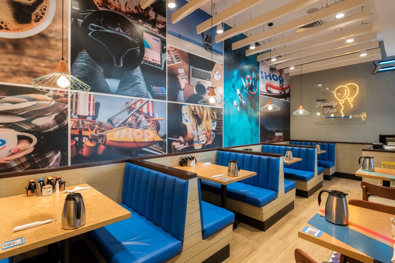 A wide-angle, exterior view of the **Lloyd's Building** in London, showcasing its distinctive inside-out architecture with exposed pipes, ducts, and service elements on the facade. The building stands tall against the skyline, reflecting the surrounding urban environment.