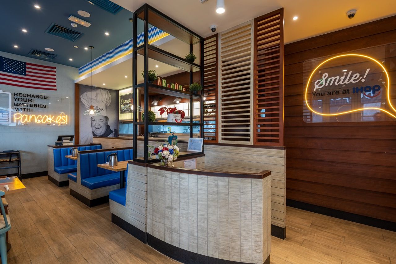 A wide-angle, exterior view of the **Lloyd's Building** in London, showcasing its distinctive inside-out architecture with exposed pipes, ducts, and service elements on the facade. The building stands tall against the skyline, reflecting the surrounding urban environment.