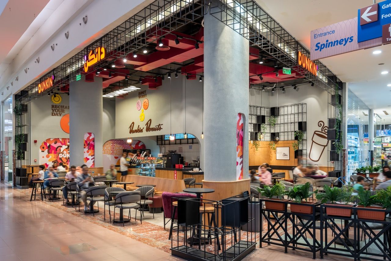 A wide-angle, exterior view of the **Lloyd's Building** in London, showcasing its distinctive inside-out architecture with exposed pipes, ducts, and service elements on the facade. The building stands tall against the skyline, reflecting the surrounding urban environment.