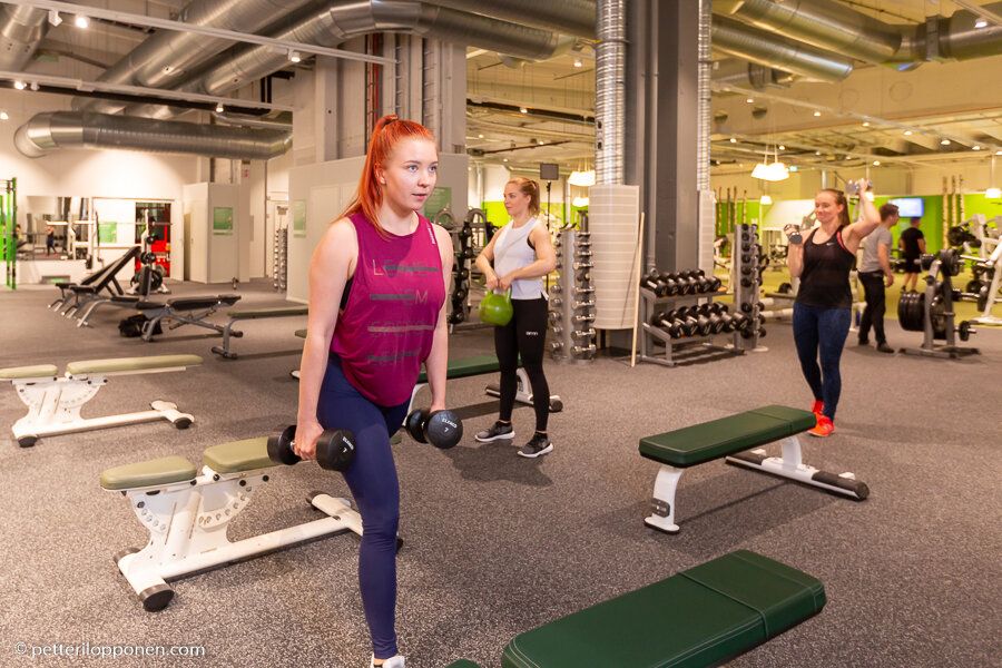 Kuntoilija tekee askelkyykkyä käsipainoilla.