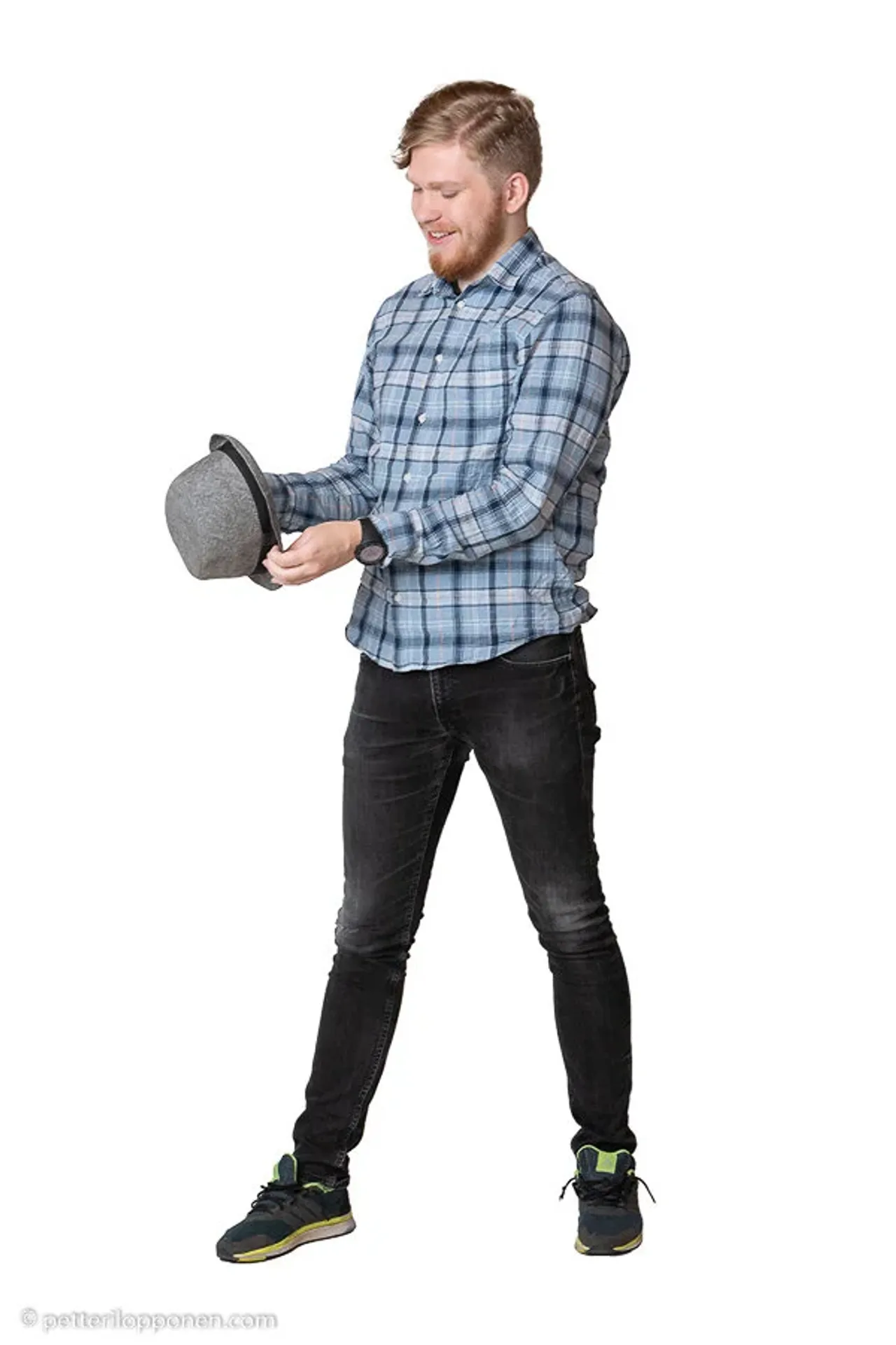 A man in a checked shirt holding his hat.