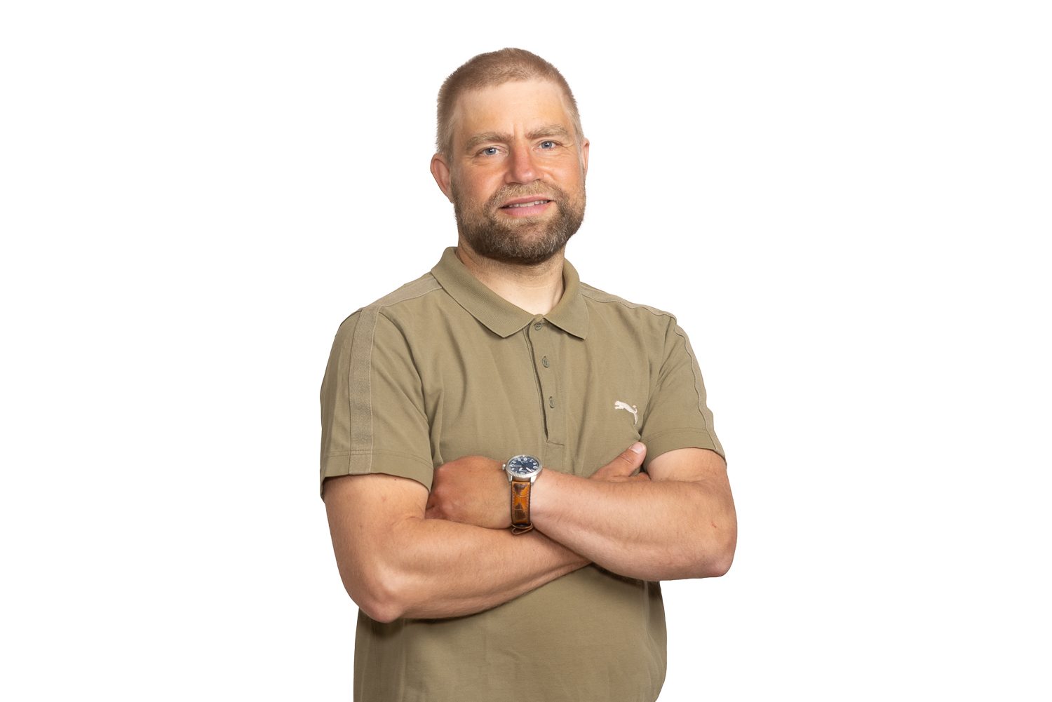 Kädet ristissä rinnalla, oliivinvihreä pikeepaita, tasainen studiovalo.