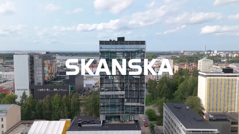 Skanskan tunnus tornitalon kyljessä sinistä taivasta vasten.