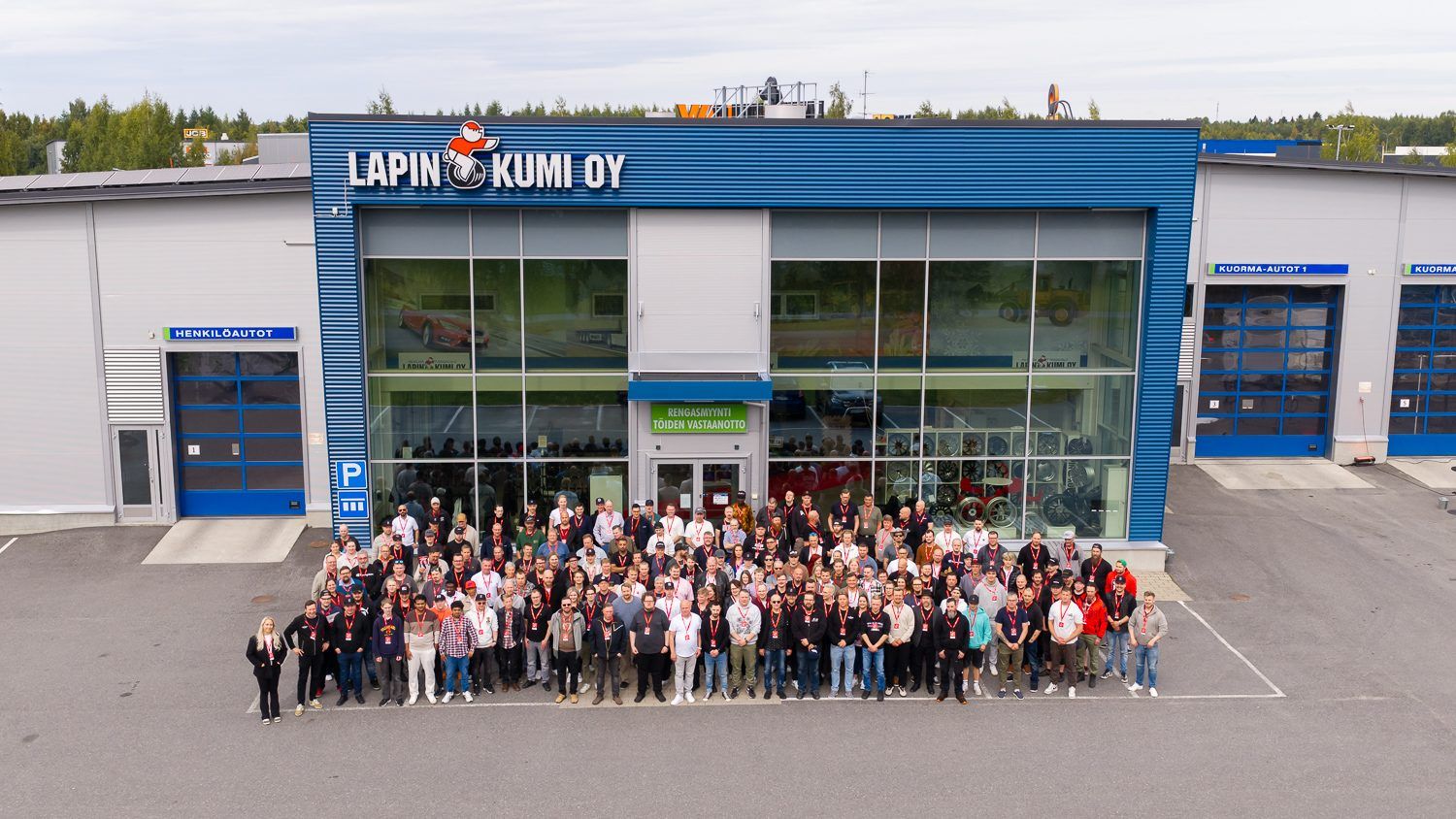 Lapin Kumin väki yhtiön nimen alla Oulun toimipisteen edessä, dronella kuvattu ryhmäkuva.
