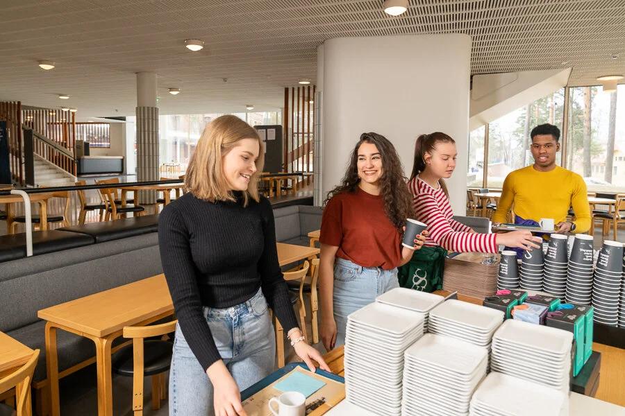 Opiskelijoita kampuskahvilan pöydän ääressä.