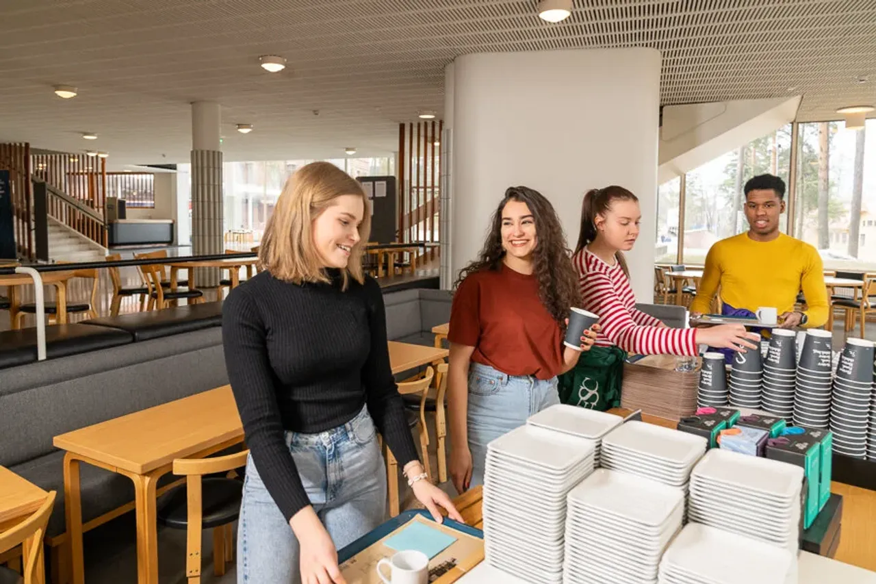 Opiskelijoita kampuskahvilan pöydän ääressä.