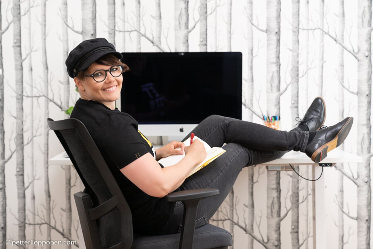  designer istuu työpöydän ääressä 