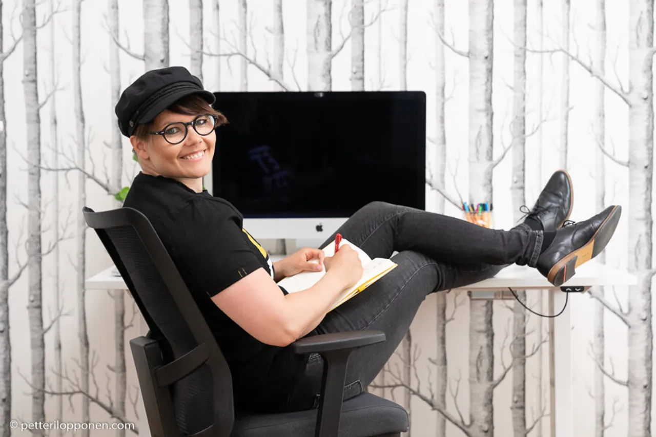 designer istuu työpöydän ääressä