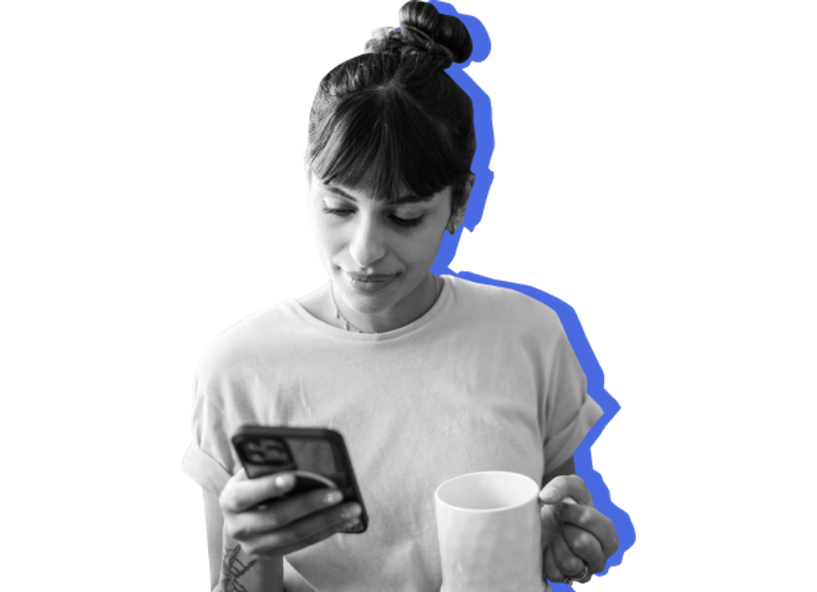 woman on phone, holding mug