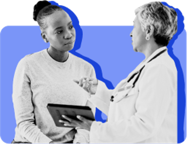 Female Black woman looking at tablet with female White doctor