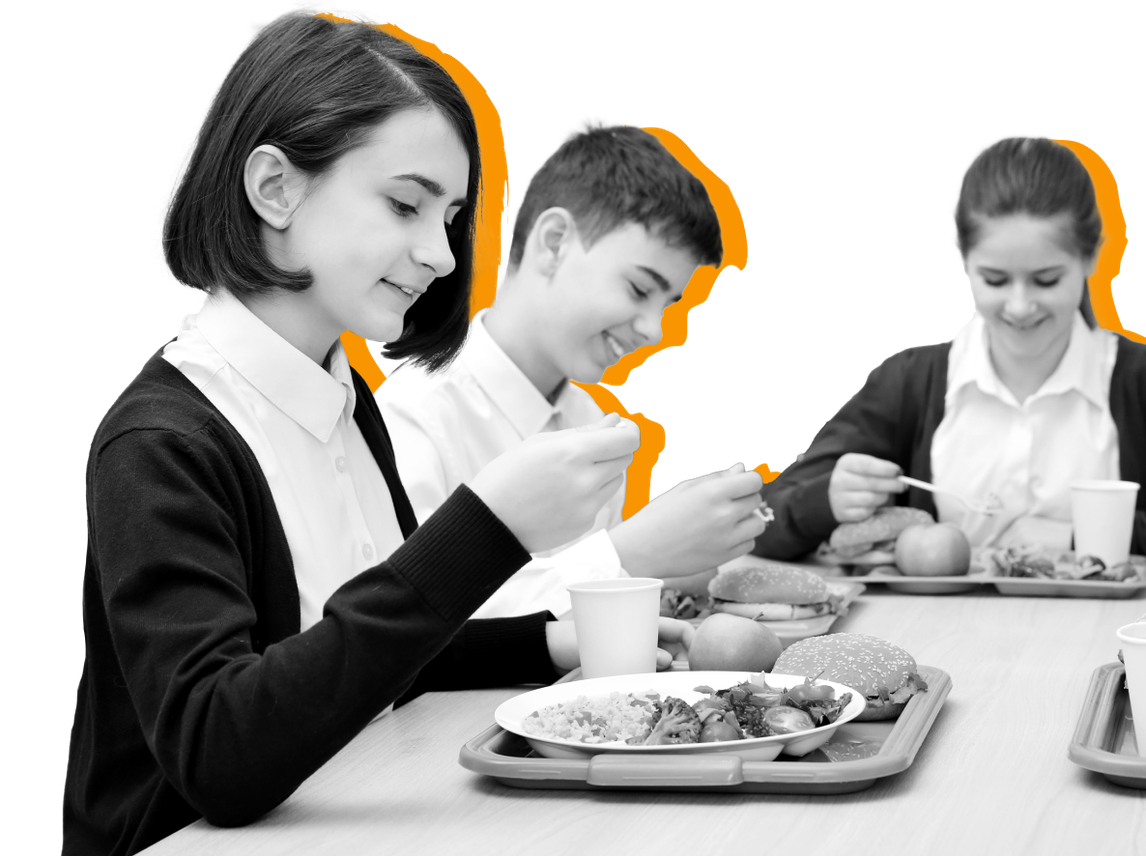 Students sit together eating lunch against a yellow backdrop 