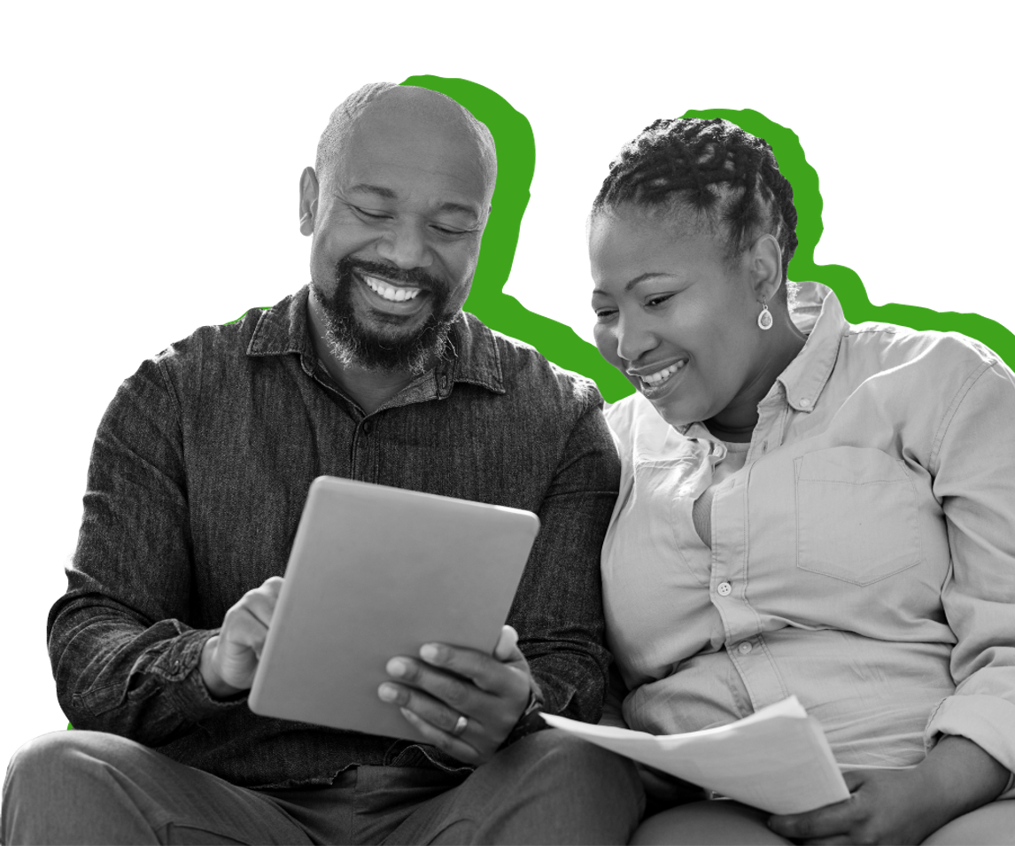 A woman and man smile while looking at an iPad screen. 