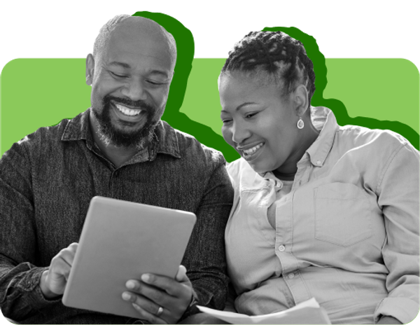A woman and man smile while looking at an iPad screen. 