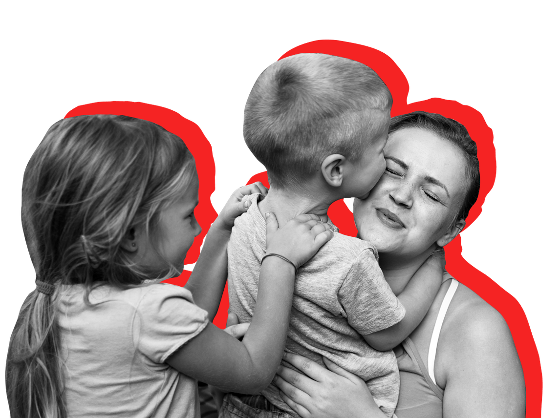 A low-income woman and children cuddle. Back-to-school season can be expensive for low-income families.