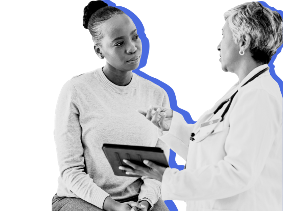 Female Black woman looking at tablet with female White doctor