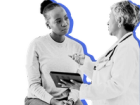 Female Black woman looking at tablet with female White doctor