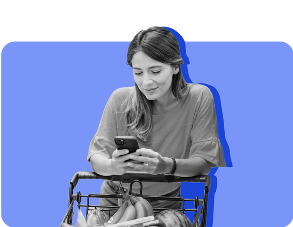 A woman looks at her phone in the grocery store