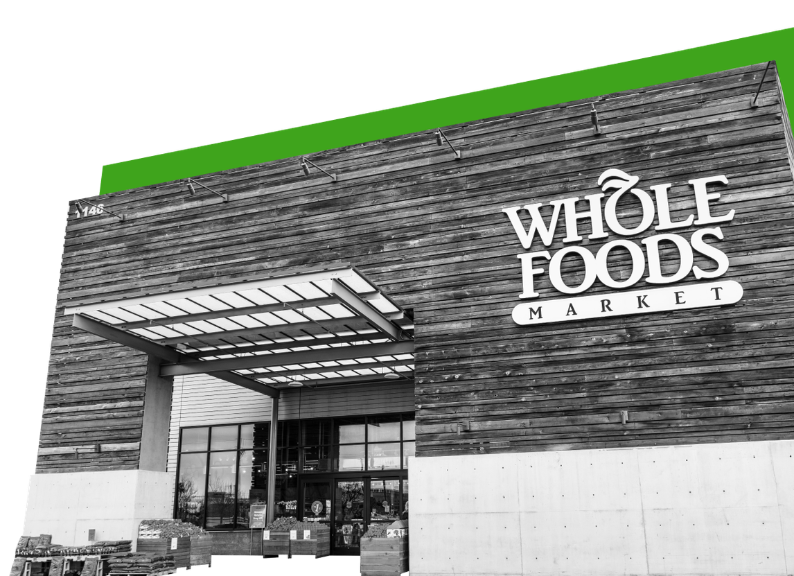 An image showing the exterior of a Whole Foods store against a green background