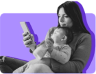 Mother holding infant in lap while looking at her phone