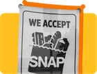 A sign that reads "We accept SNAP" against a yellow background