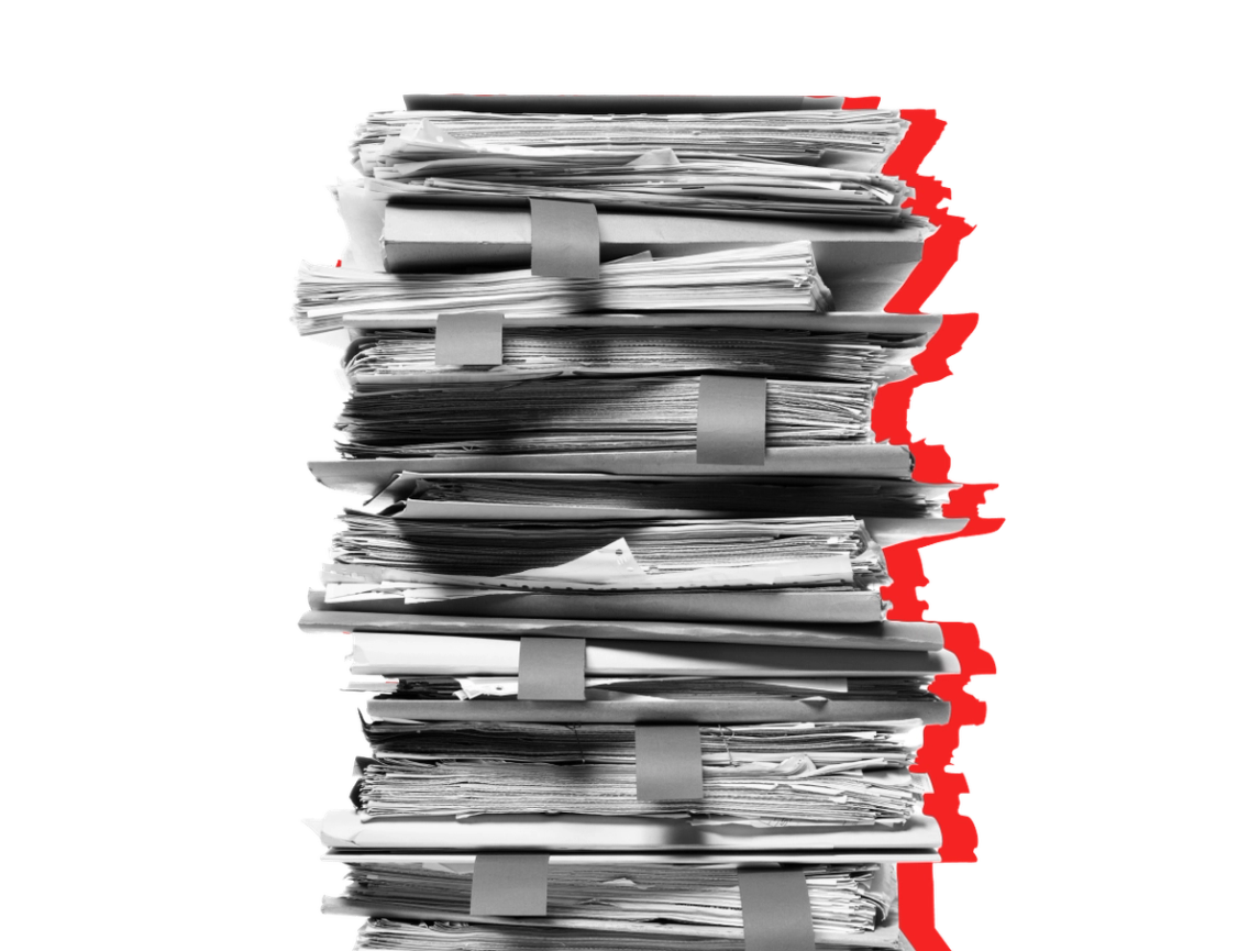 A stack of papers related to Medicaid renewal seen against a red background