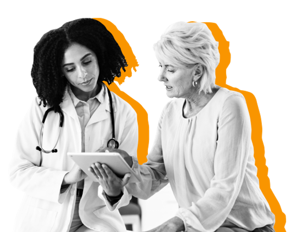Black female doctor wearing a stethoscope, looking at tablet with white female patient