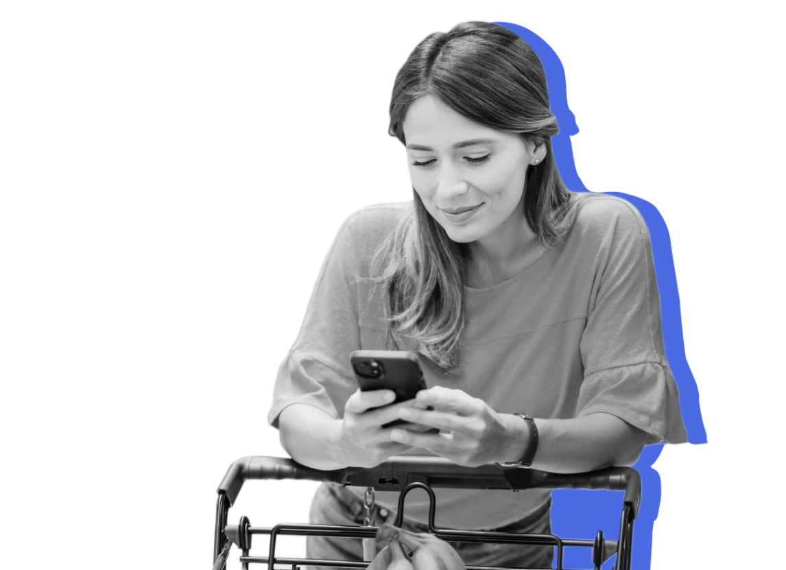 A woman looks at her phone at the grocery store