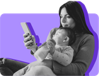A mom holds her baby while looking at her mobile phone