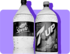 A bottle of Sprite and a bottle of 7 Up stand next to each other. 