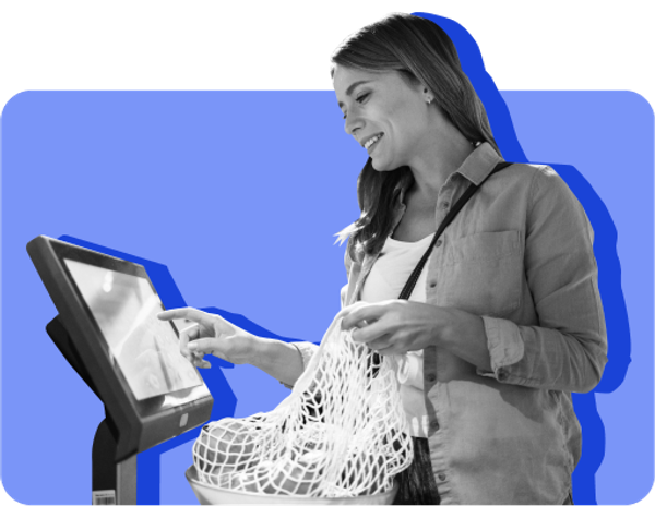 A person with long hair checks out at a grocery store and saves money by buying in bulk and comparison shopping