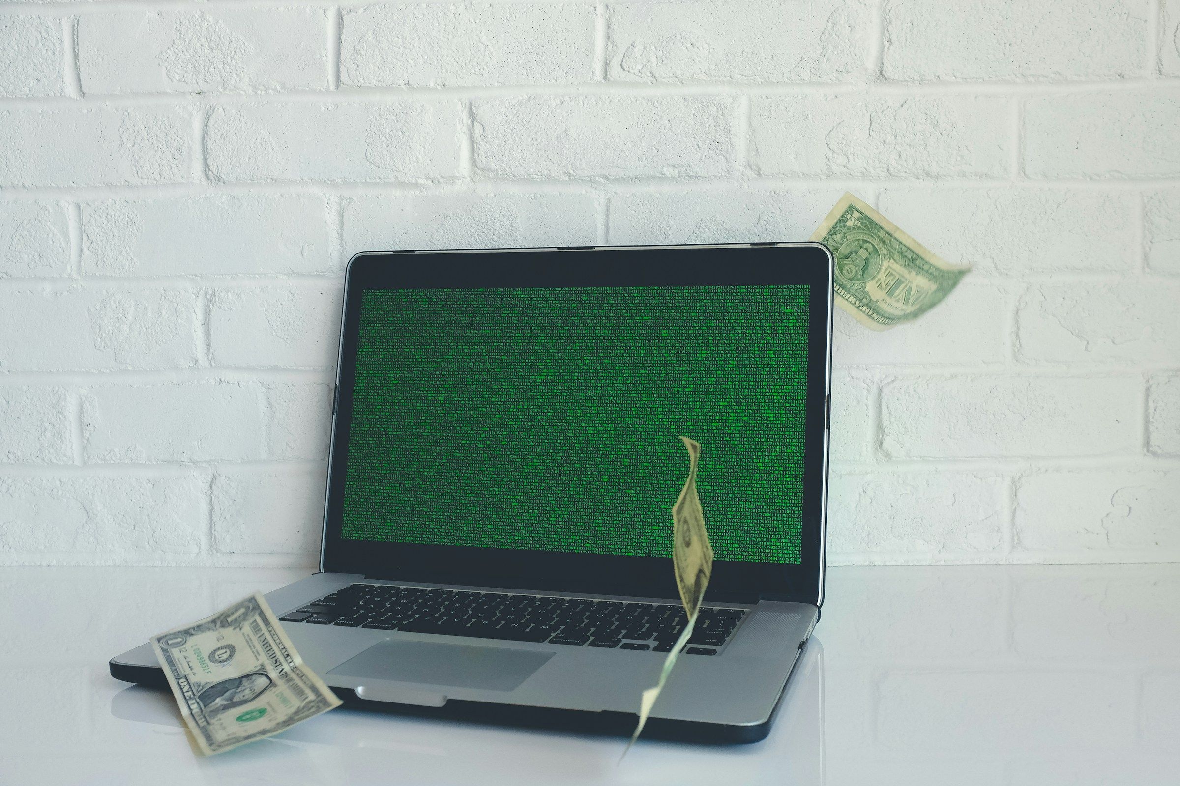 Laptop screen with revenue chart and cash illustrating white label fan site revenue growth