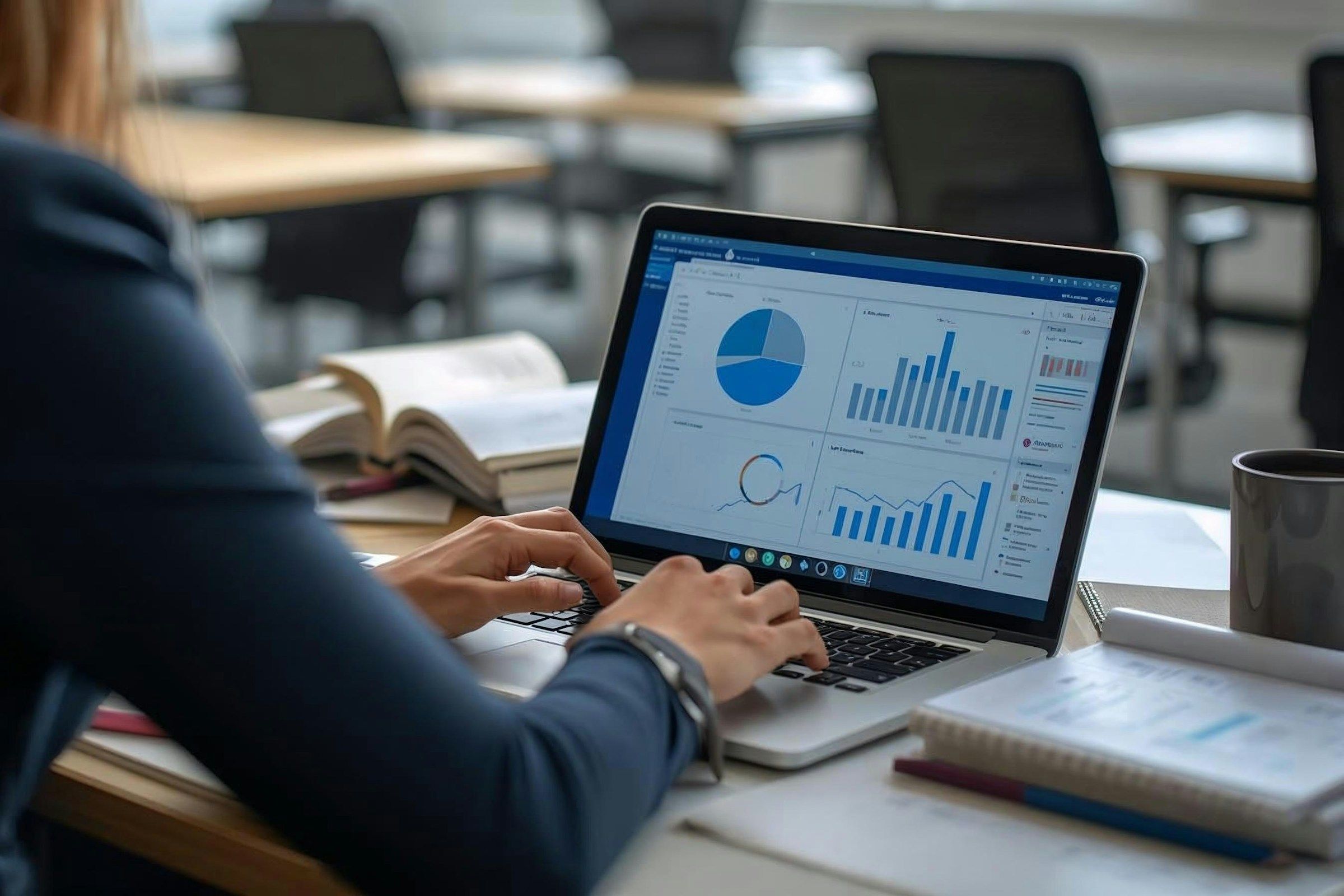 Woman working on laptop with charts and graphs.