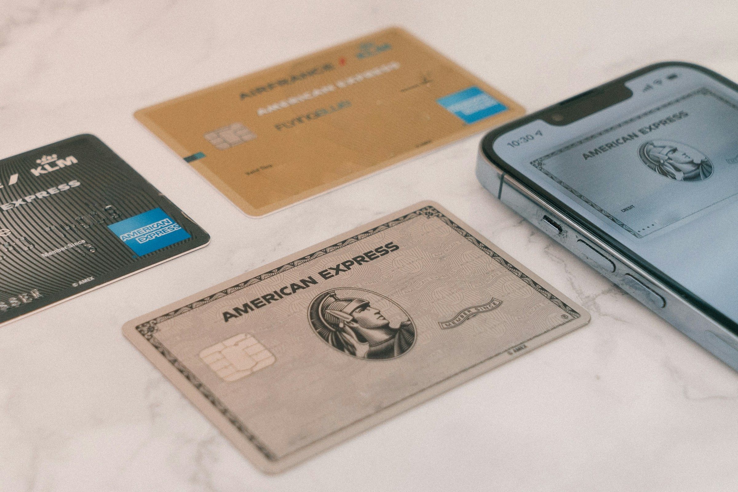 a group of credit cards sitting next to a cell phone