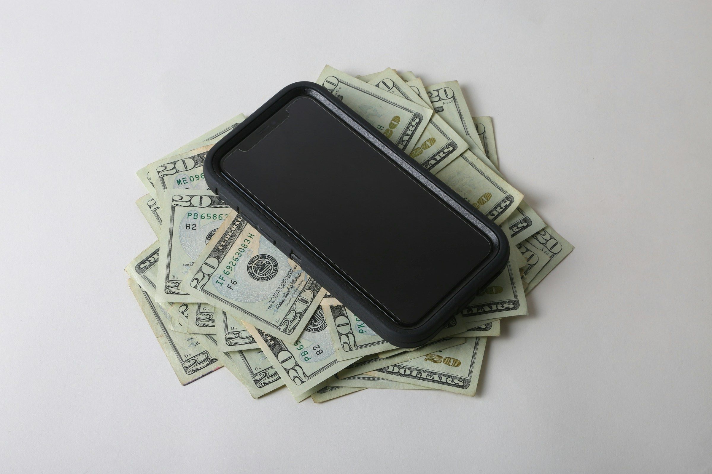 a cell phone sitting on top of a pile of money