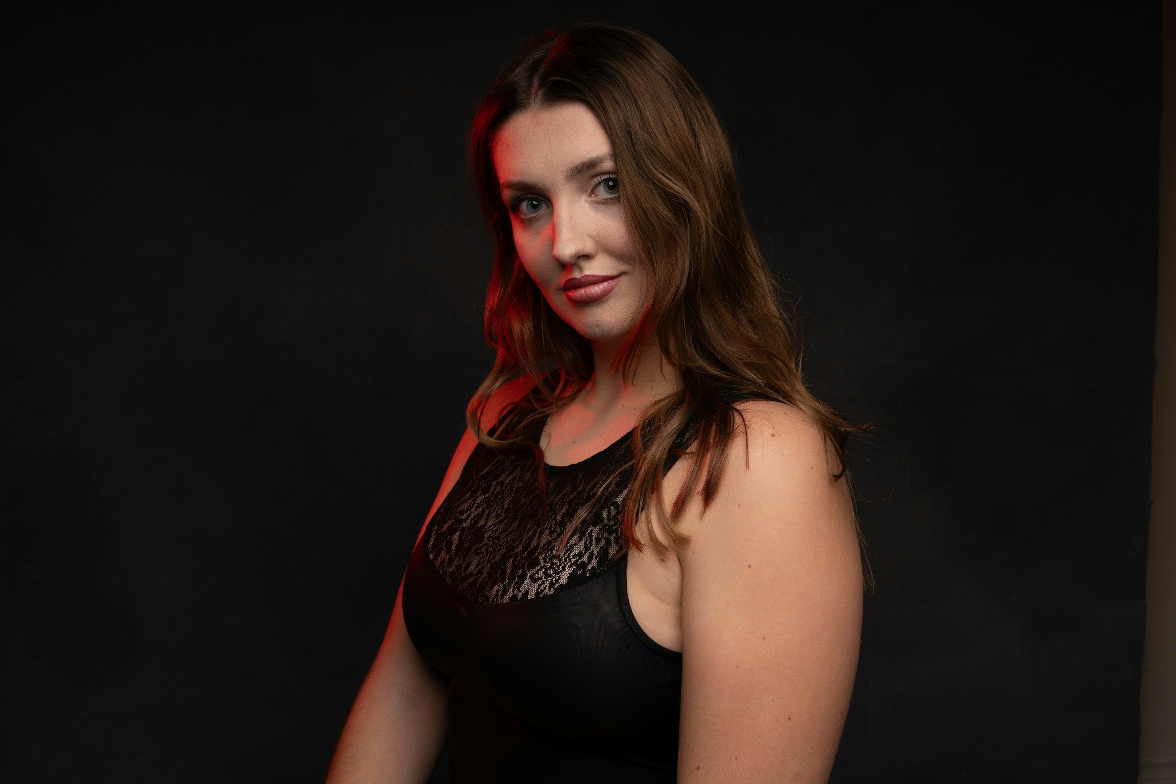 A woman in a black dress with red lighting