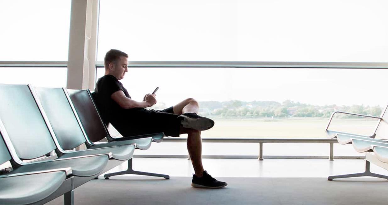 Man sitting in airport reading on Glowlight 4